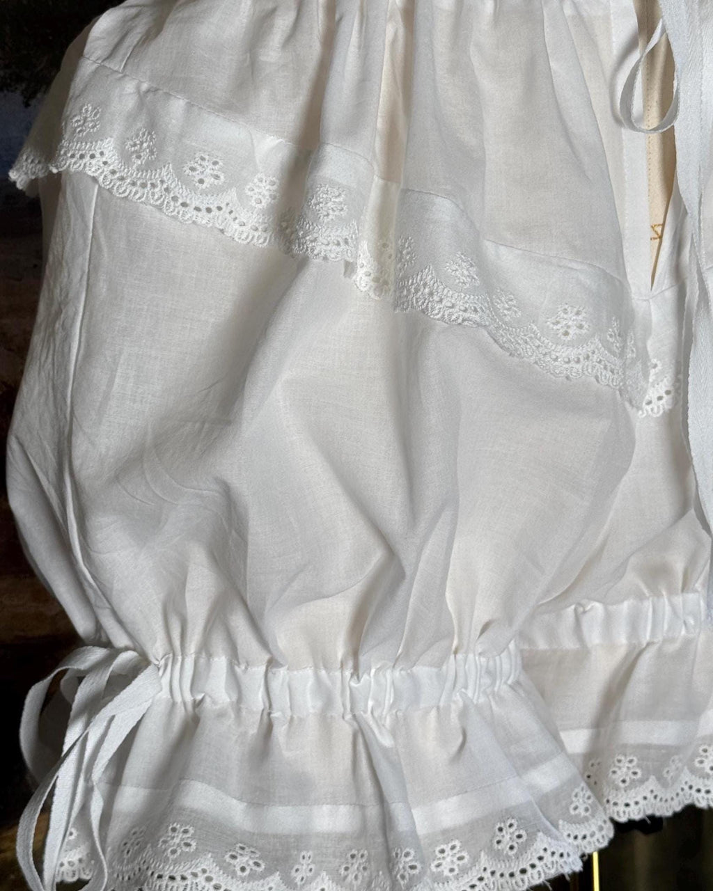 Close-up of the eyelet lace and side bow on the bloomers