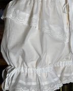 Close-up of the eyelet lace and side bow on the bloomers