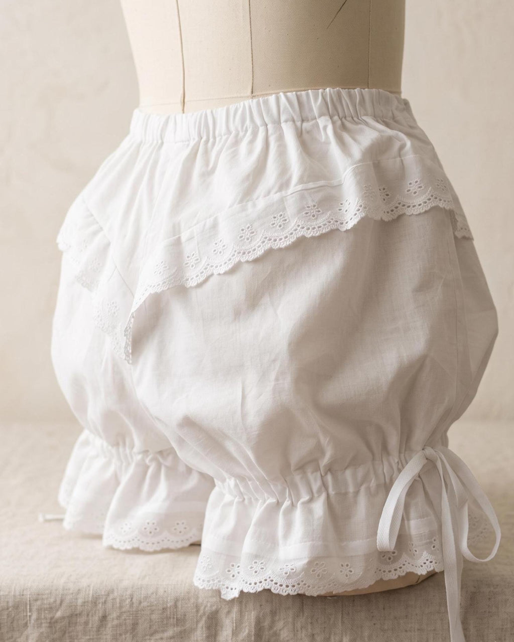 Close-up of the ruffled lace hem of the white bloomers