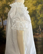 Close-up of the lace-trimmed sleeve tie on the white chemise