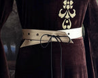 Cream vegan leather belt laced over a dark velvet gown