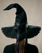 Back of the black witch hat showing the hand-frayed brim