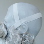 Elastic strap of the grey wig shown on a mannequin head