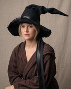 Woman in the black witch hat with a hand-frayed brim and ribbon ties