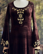 Brown velvet dress on a dress form showing the gold bodice appliqué