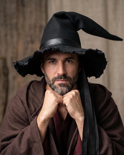 Man wearing the black witch hat with its bent asymmetrical peak