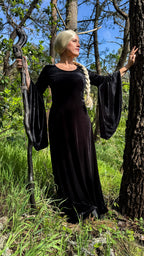 Brown velvet medieval dress worn among pine trees